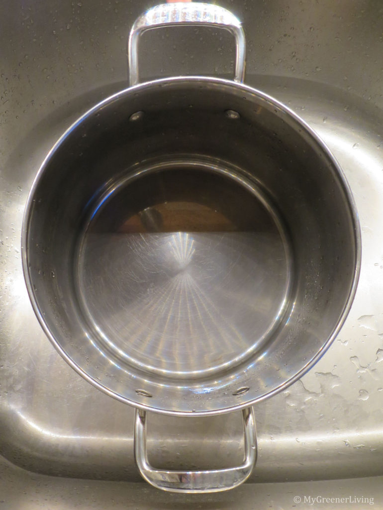 photo of a shiny clean pot after being scrubbed with a stainless steel chain mail scrubber, soap, and water