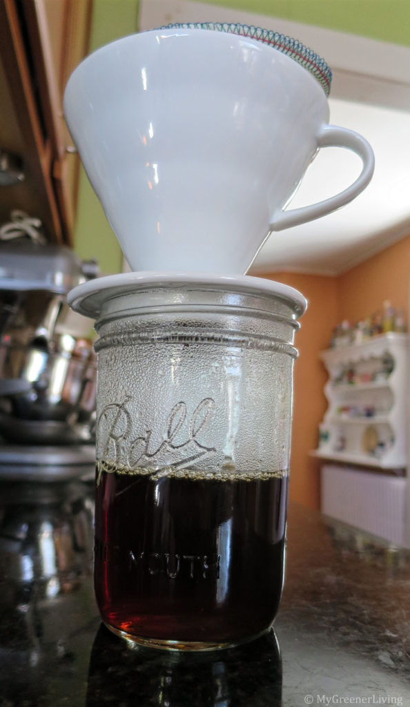 ceramic cone coffee maker over a mason jar with brewed coffee in jar